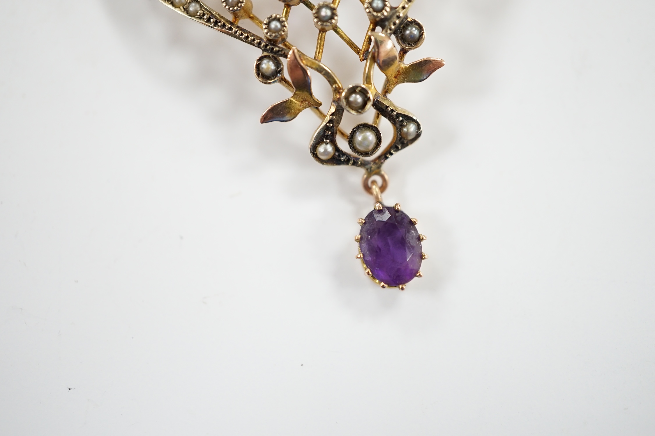 An Edwardian Art Nouveau 9ct, amethyst and seed pearl set drop pendant, 50mm, gross weight 5.2 grams.